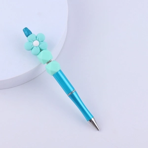 Detailed view of DIY blue beaded pen featuring turquoise silicone flower and decorative beads
