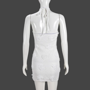 Détail de la robe mini dos nu blanche avec dentelle florale 3D et décolleté licou chic
