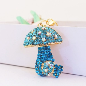 Sparkling blue rhinestone mushroom keychain with gold metal frame and colorful accents