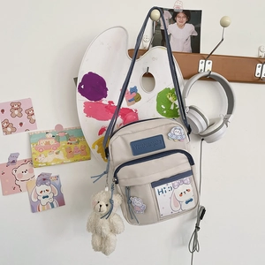 Détail d'un sac bandoulière en toile style japonais avec poche transparente et ours peluche