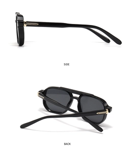 Detail view of retro black sunglasses with gold T-shaped metal hinges and gray lenses