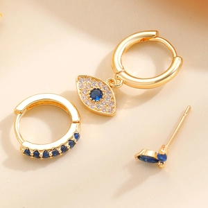 Macro shot of gold devil eye earrings with blue stones and zircon micro-pave detailing