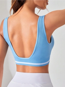 Détail de la brassière de yoga bleue avec dos en U profond et ourlet côtelé à rayures