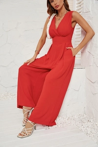 Detail of red sleeveless V-neck wide leg jumpsuit showing drapes and fabric texture