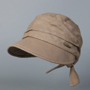Detail of coffee-colored cotton linen sun hat with pleated texture and gold metal logo