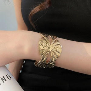 Nahaufnahme des goldfarbenen Manschettenarmbands mit elegantem Hammerschlag-Design