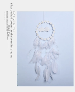 Close-up of white daisy floral dreamcatcher with fluffy clouds and soft feathers