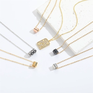 Close-up of minimalist square pendant necklaces with crystal details on stone background