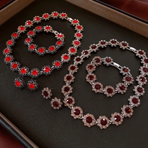 Macro view of vintage floral jewelry sets with red and amber stones in a black gift box