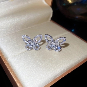 Detailed close-up of sparkling zircon butterfly stud earrings in a luxury jewelry box