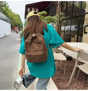 Brauner Cord-Rucksack für Damen in einer Outdoor-Street-Lifestyle-Umgebung gezeigt
