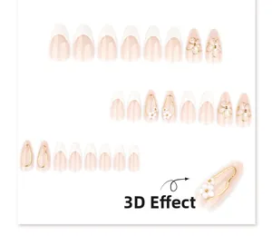 Detail of nude pink press-on nails with white 3D flowers and French tips with golden wire