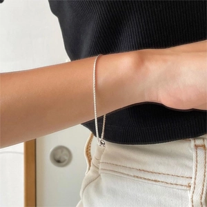 Detailed close-up of a minimalist S925 sterling silver snake chain bracelet on a wrist