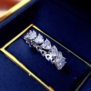 Macro shot of silver heart-shaped eternity ring with row of heart-cut stones in a box