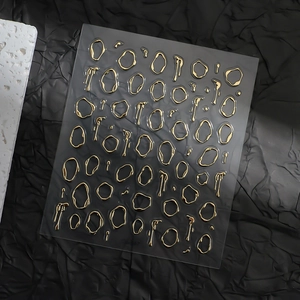 Detailed view of 3D metallic gold nail stickers featuring abstract liquid and irregular shapes