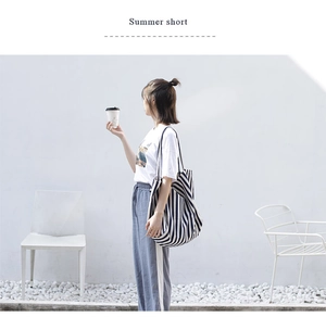 Detail of durable black and white striped canvas tote bag with seamless shoulder strap