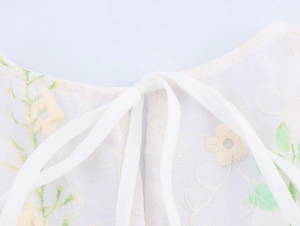 Detail of back neckline showing delicate floral embroidery and adjustable tie closure