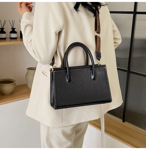 Detail of vintage black tote bag featuring contrast stitching and jacquard strap