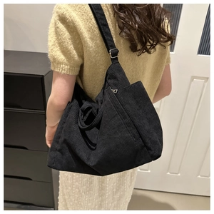 Model wearing a black corduroy crossbody tote bag for a casual spring 2024 fashion look