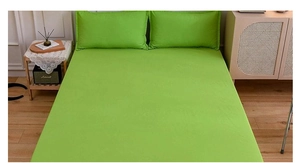 Detail view of bright green fitted sheet and pillowcase set on a minimalist bed