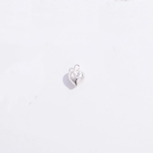 Macro shot of polished silver heart pendant with top ring for DIY necklace making