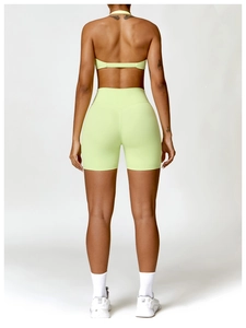 Back view of neon green backless yoga bra and high-waist fitness shorts for women