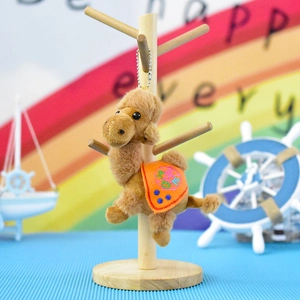 Detailed view of a cute brown plush camel keychain with an orange embroidered saddle.