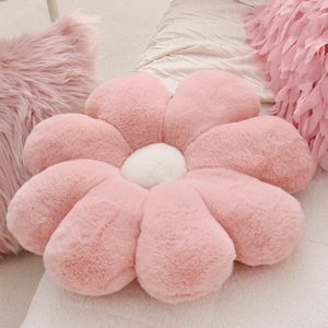 Close-up of pink flower-shaped plush pillow with soft texture and white stamen detail