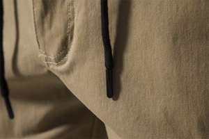 Detail of khaki twill cotton fabric texture with a black drawstring on men's cargo pants