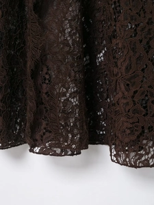 Detailed macro view of dark brown floral lace fabric with intricate hollow patterns