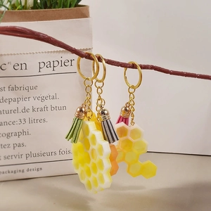 Gros plan de porte-clés alvéolés en résine avec glands colorés sur une branche