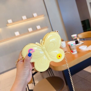Close-up of yellow butterfly jelly bag with rainbow and sunflower charms and gold chain