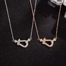 Detailed top view of silver and rose gold horseshoe necklaces with pavé diamonds