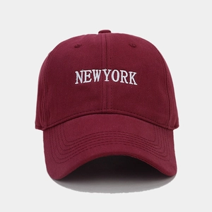 Close-up of white NEW YORK embroidery on a burgundy cotton twill baseball cap