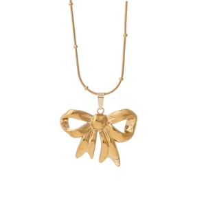 Golden bow pendant necklace with delicate snake chain and bead accents on white background