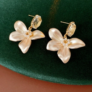 Detail of floral earrings with pearl petals and crystal drops on velvet background