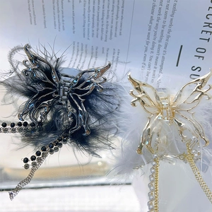 Elegant butterfly hair claw clip with feathers and pearl tassels on a magazine background