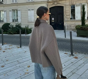 Street style view of a brown wool coat with a relaxed silhouette and notched collar