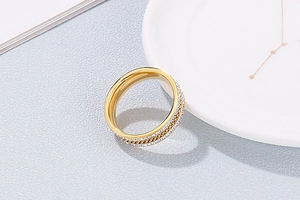 Detailed view of gold plated titanium steel ring with sparkling crystals and woven texture