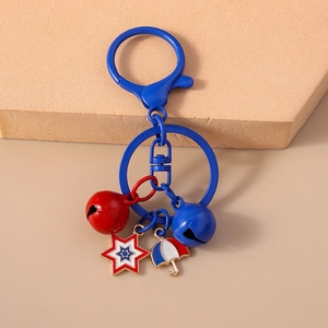Detail of metal keychain featuring red and blue bells with star and umbrella charms