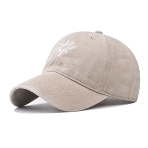 Close-up of white sun embroidery on washed cotton beige baseball cap with stitch detail