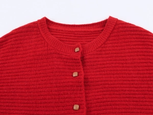 Detail of red knit cardigan featuring square wooden buttons and round neck texture