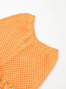 Detailed macro view of vibrant orange crochet knit top with intricate hollow-out texture