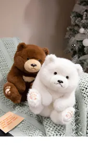 Brown and white teddy bears sitting on a knitted blanket in a cozy room setting