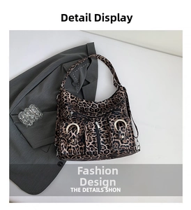 Detail of leopard print tote bag featuring multiple zipper pockets and metal rings