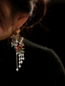 Gros plan de boucles d'oreilles papillon vintage avec émail bleu et perles blanches