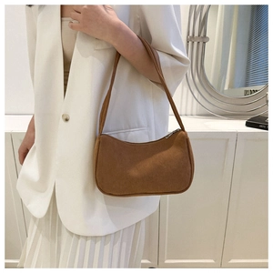 Brown corduroy shoulder bag styled on a model's shoulder for a modern baguette look