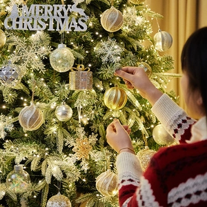 Sapin de Noël enneigé avec ornements dorés et argentés et lumières décoratives chaudes