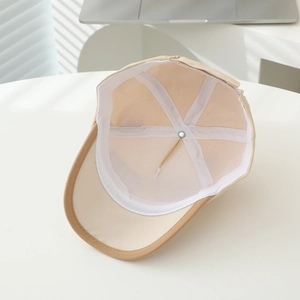 Detail of child's baseball cap showing breathable mesh lining and reinforced stitching