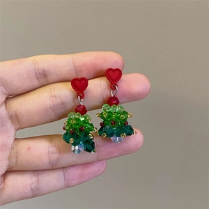 Detail of handmade beaded Christmas tree earrings with red heart and crystals
